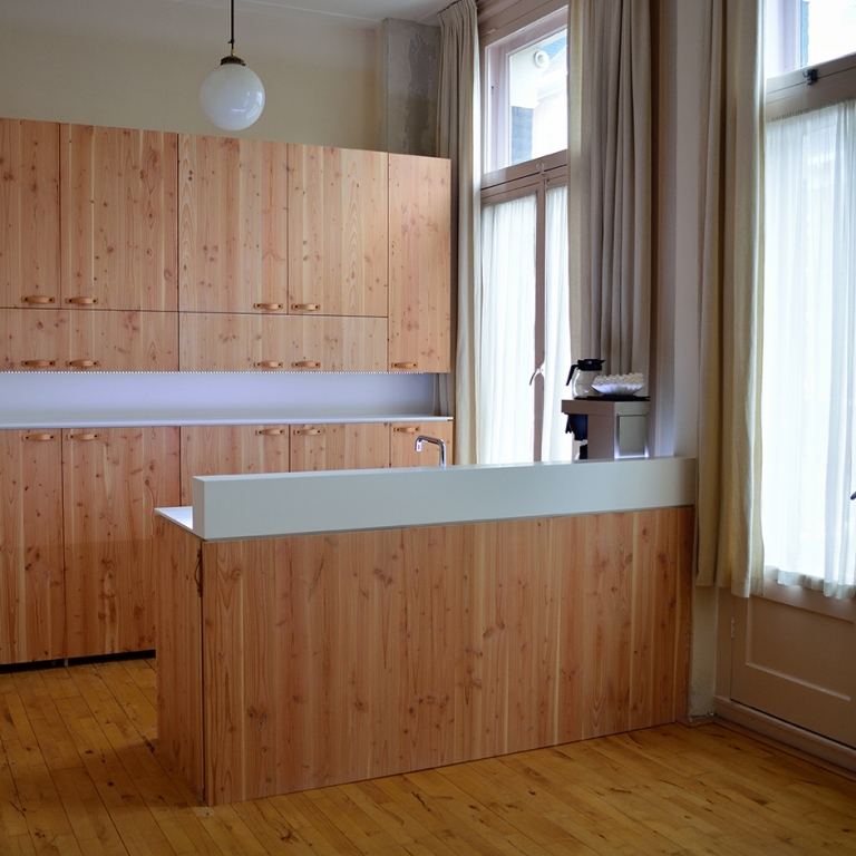 Keuken, pantry fronten gemaakt van pools grenen met leren greepjes. Aanrechtblad gemaakt van Hi-macs alpine white met led verlichting.